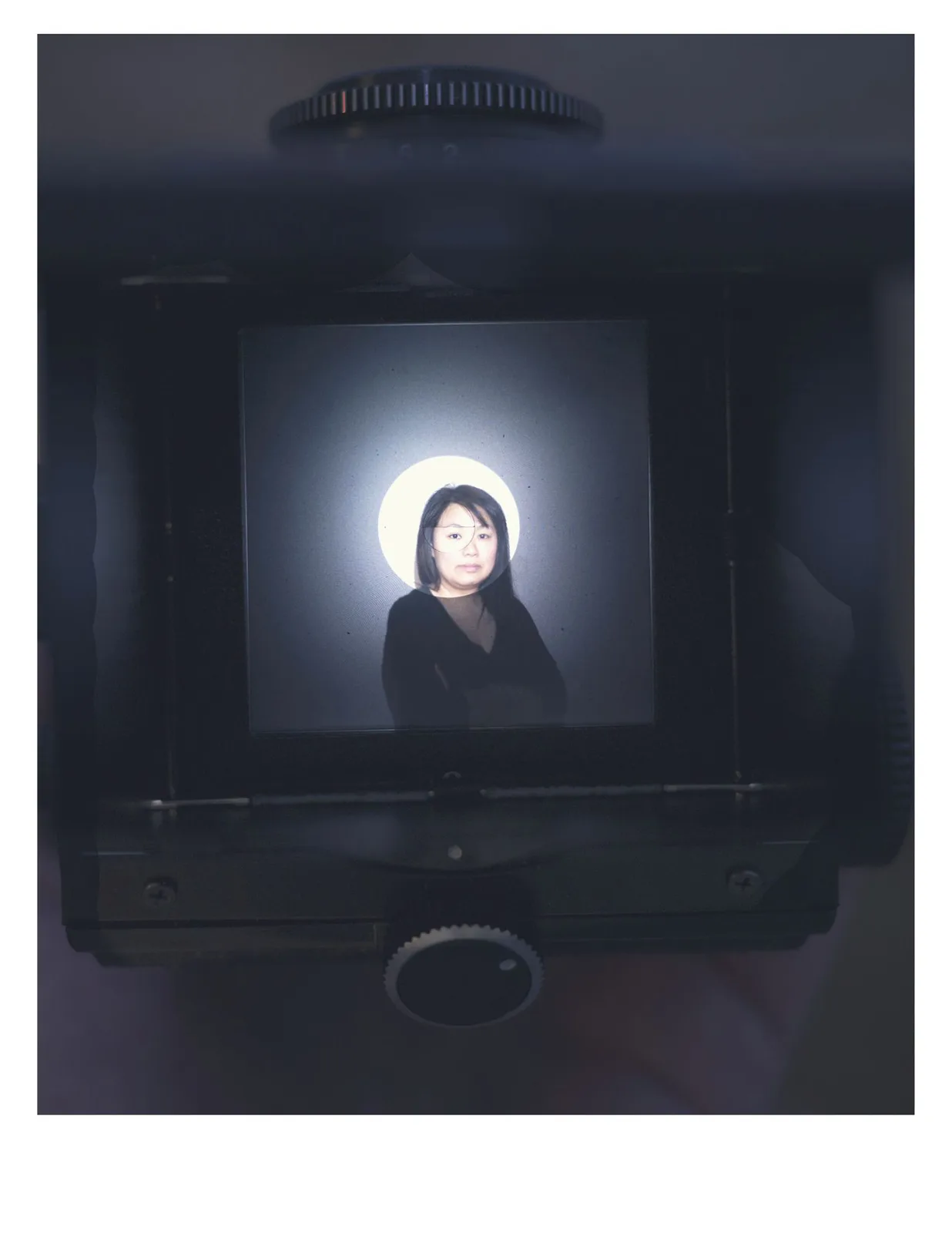 Elaine Chan-Dow self portrait viewed through a circular illuminated frame.